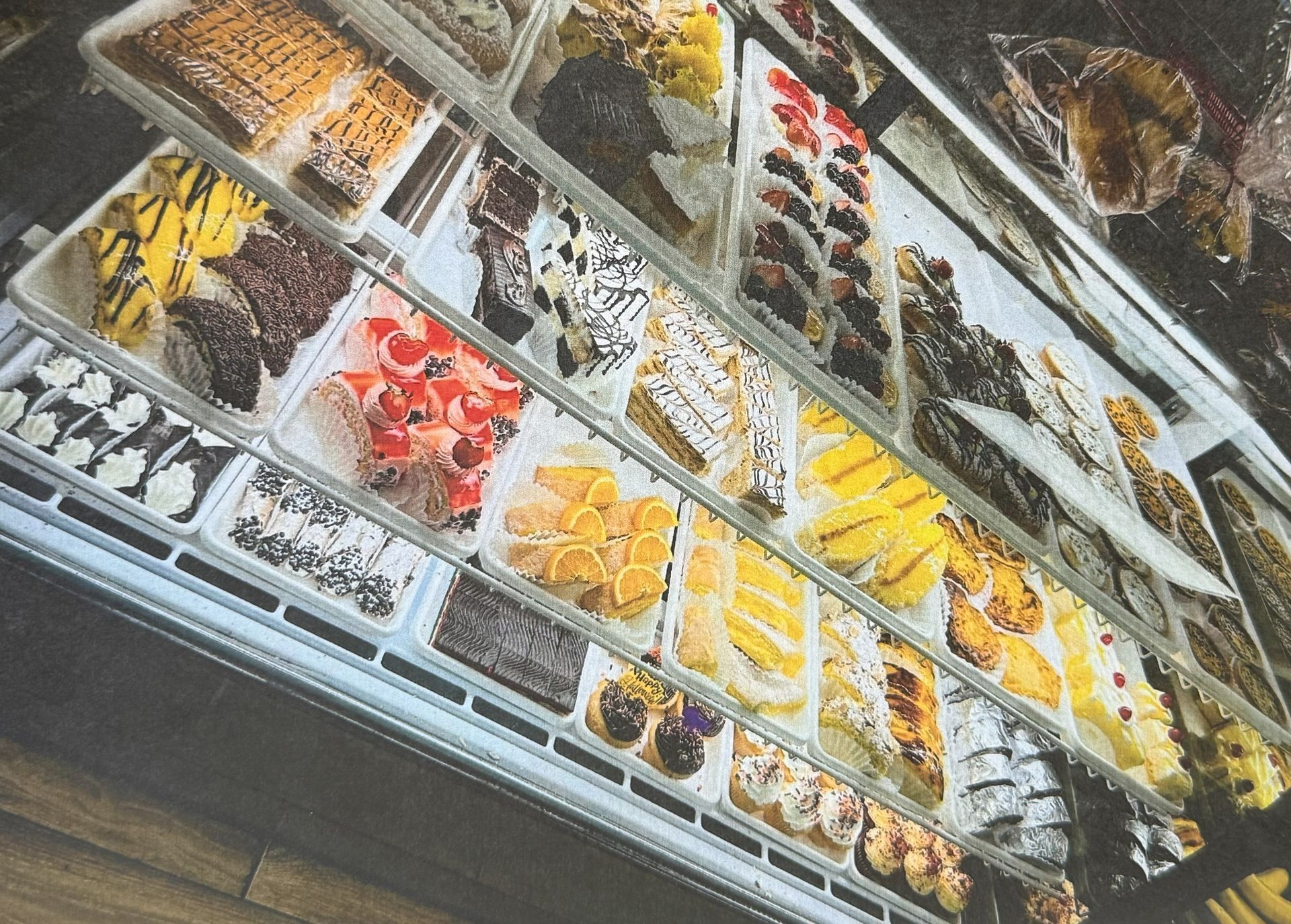 Display case filled with various colorful pastries and desserts.