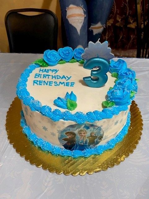 A birthday cake with blue frosting, roses, 