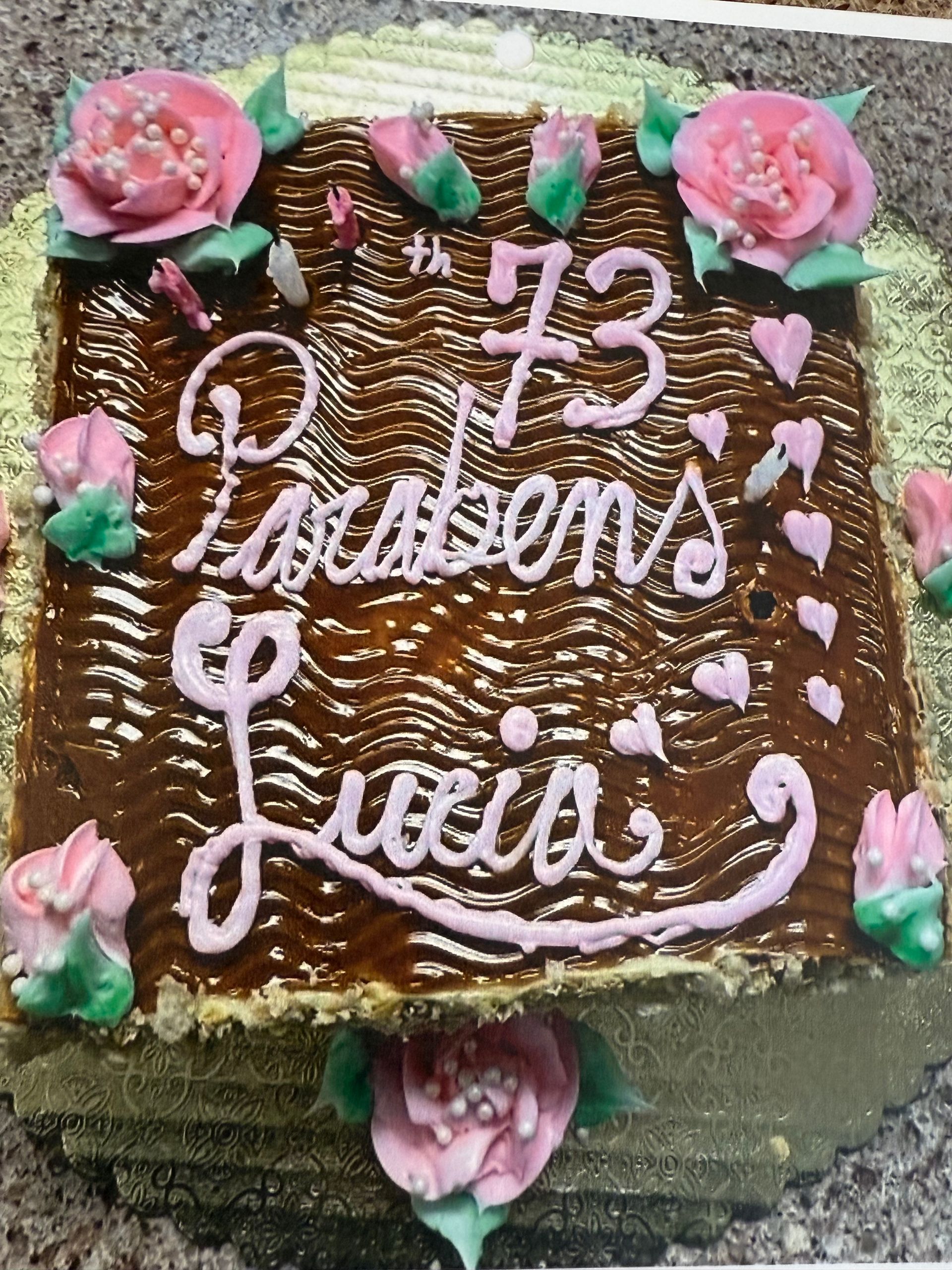 Birthday cake with caramel frosting, pink flowers, and 