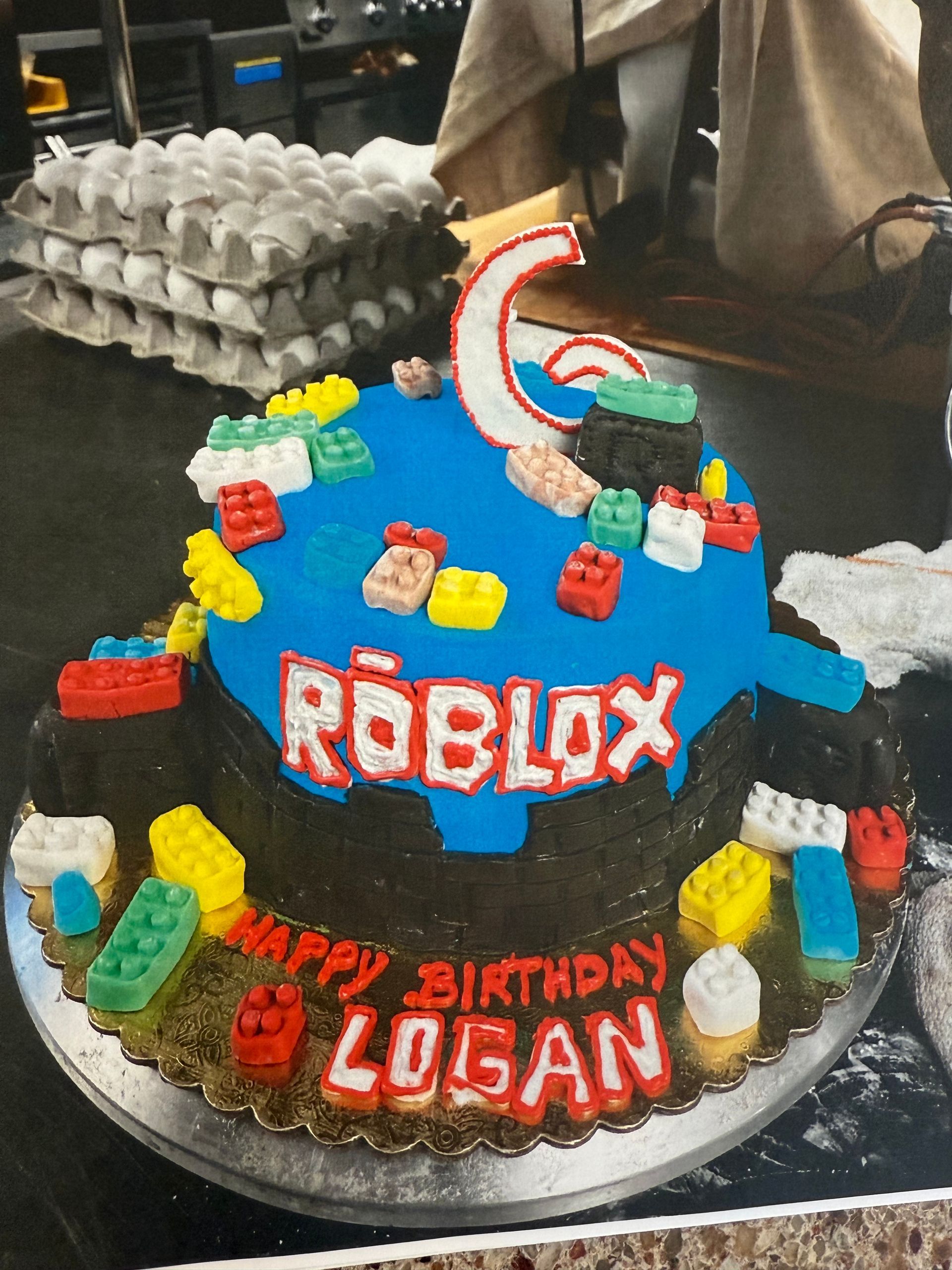 Roblox birthday cake with colorful frosting, LEGO decorations, and the number 6.