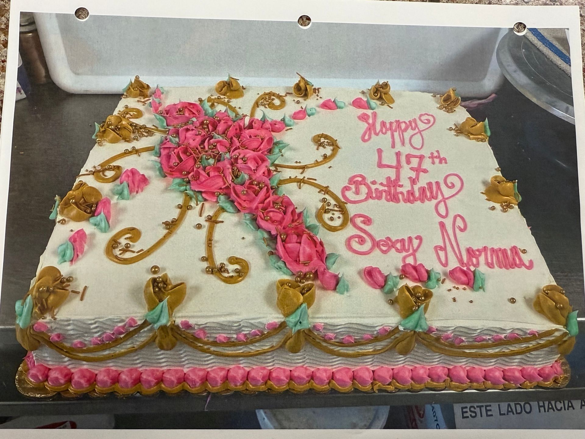 Birthday cake decorated with pink frosting, roses, and 