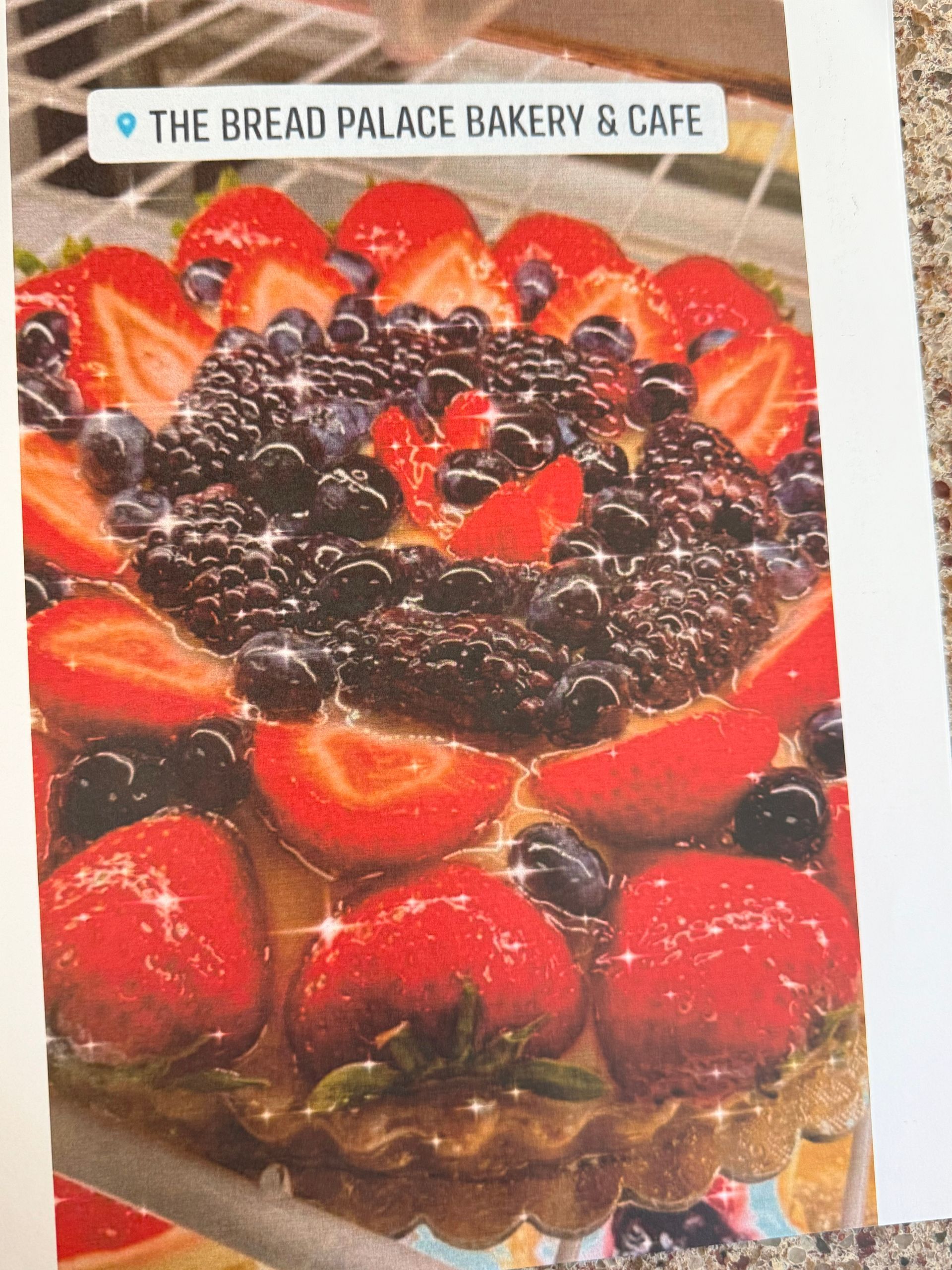 Fruit tart from The Bread Palace Bakery & Cafe, topped with strawberries, blackberries, and blueberries.