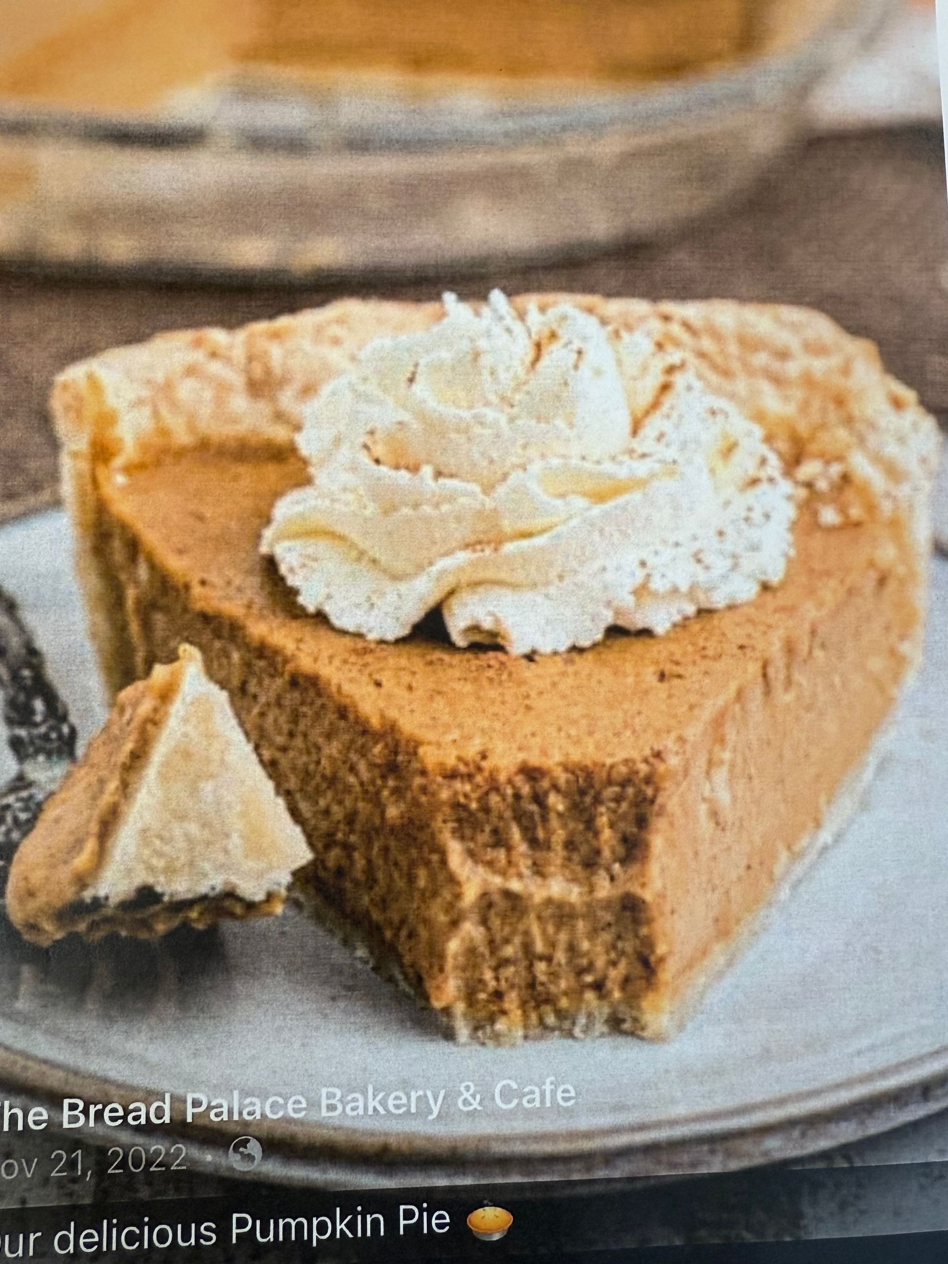 Slice of pumpkin pie with whipped cream on a plate.