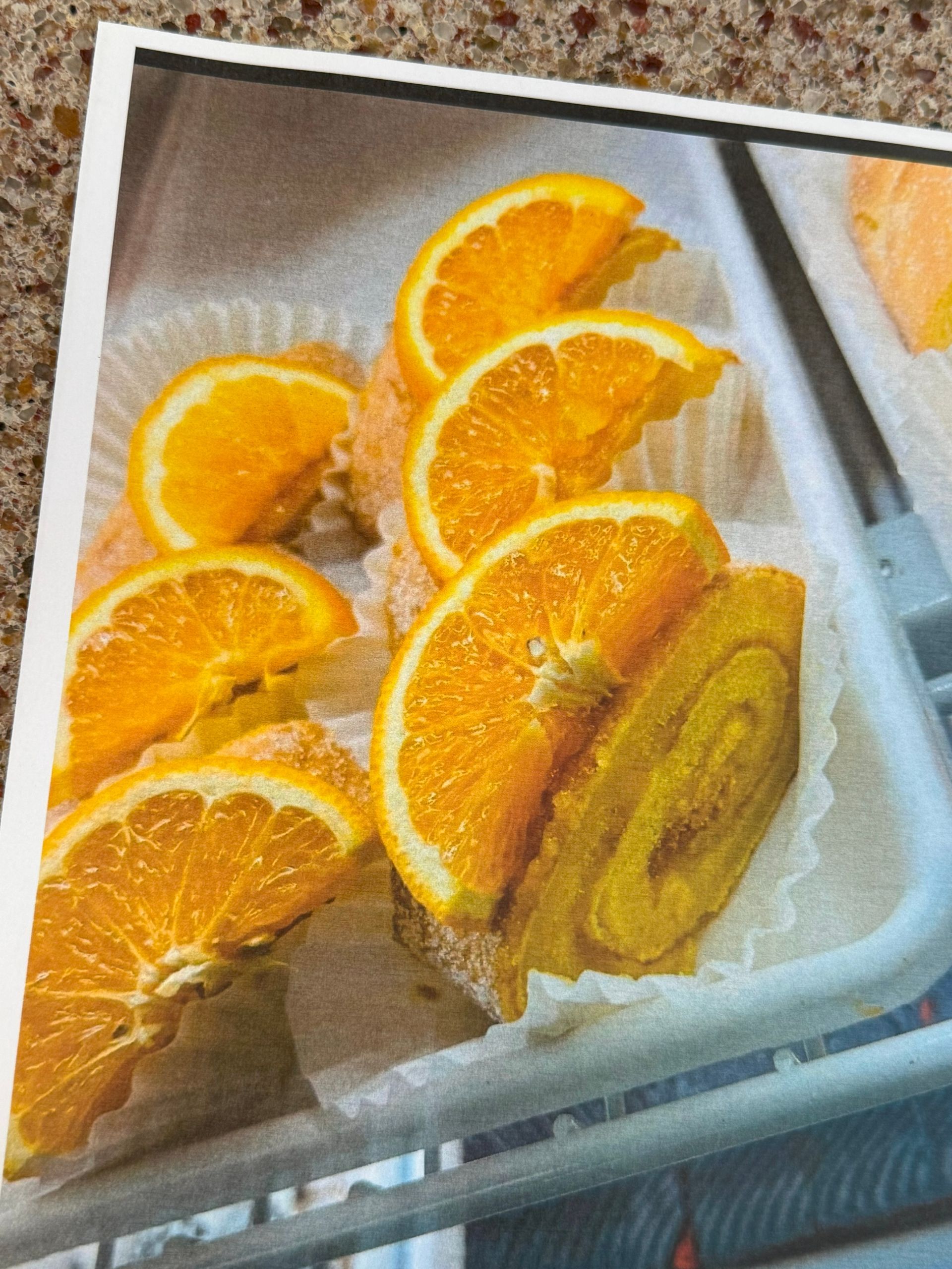 Orange cake slices topped with orange slices in a white tray.