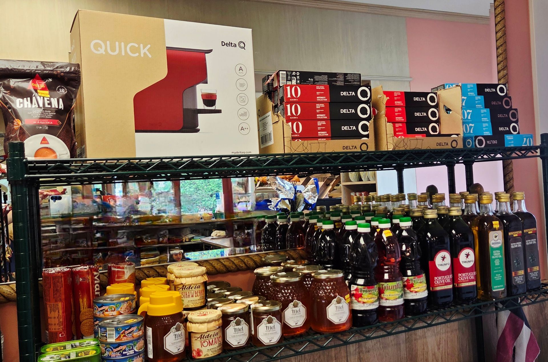 Shelves stocked with food products, including coffee makers, honey, syrups, and canned goods.