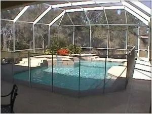 Pool enclosed by screen, surrounded by a safety fence.