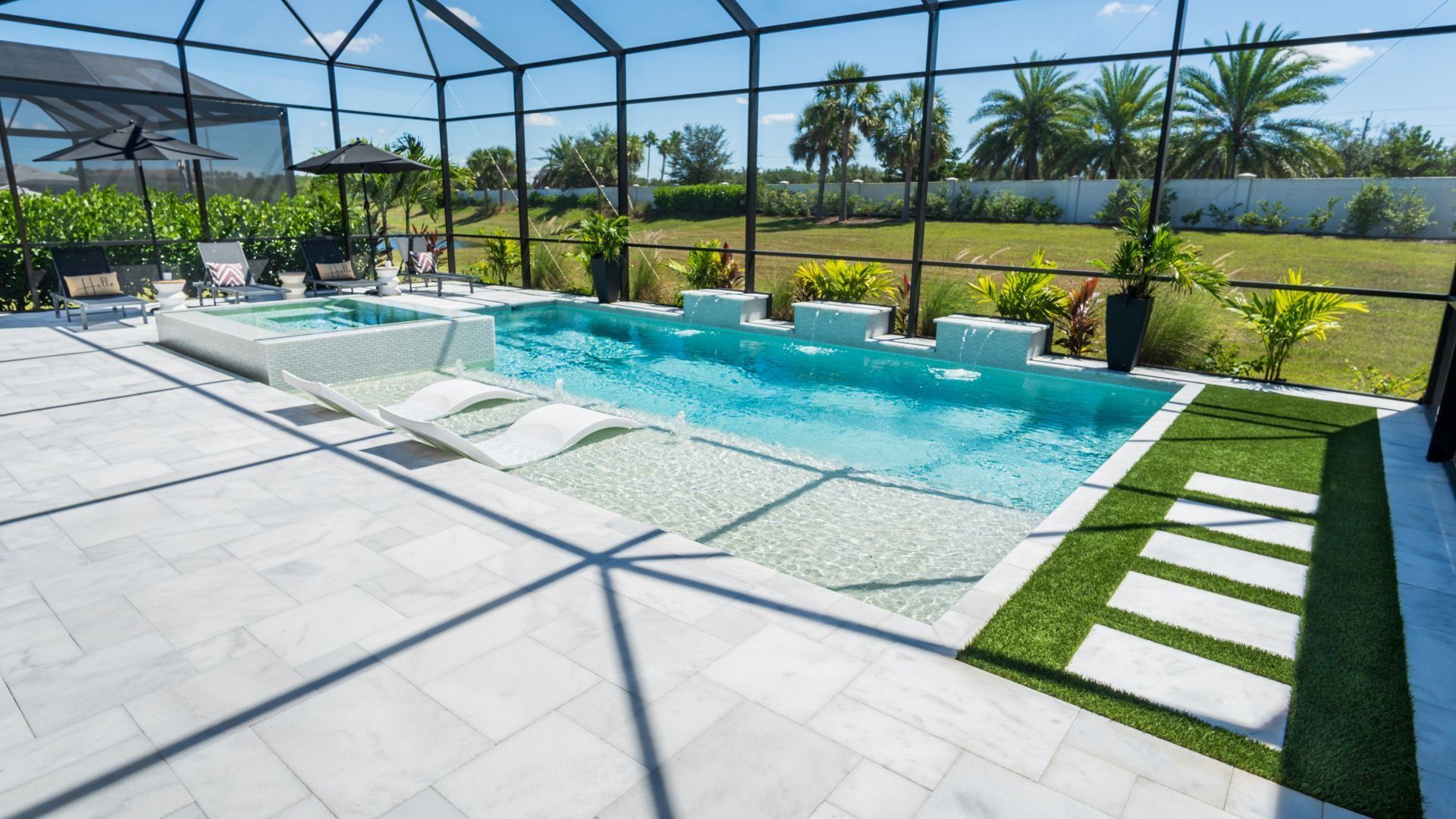 Sunlit backyard pool with loungers, white deck tiles, and palm-lined screened enclosure