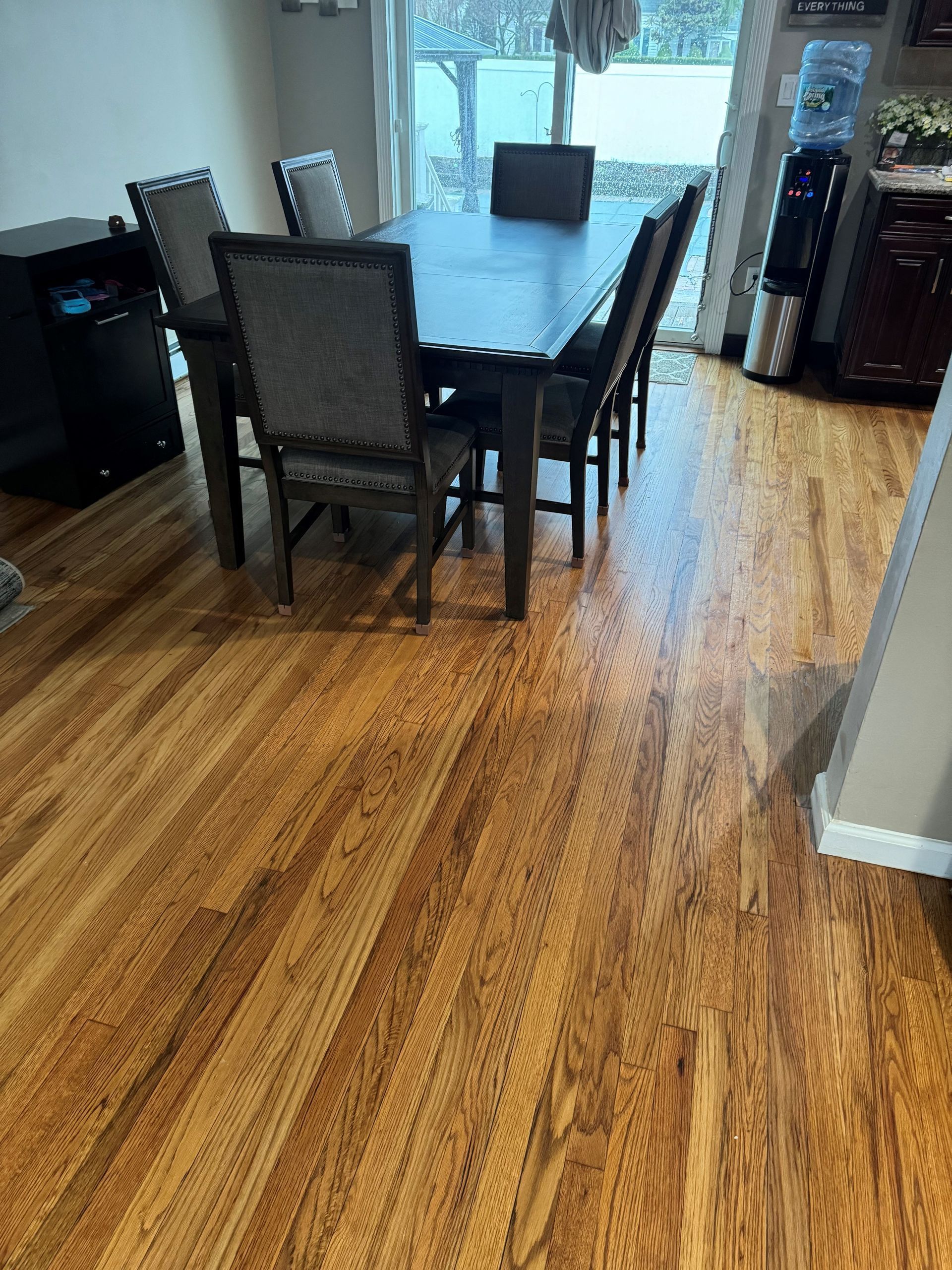 Dining room with dark wooden table and chairs on hardwood floor.