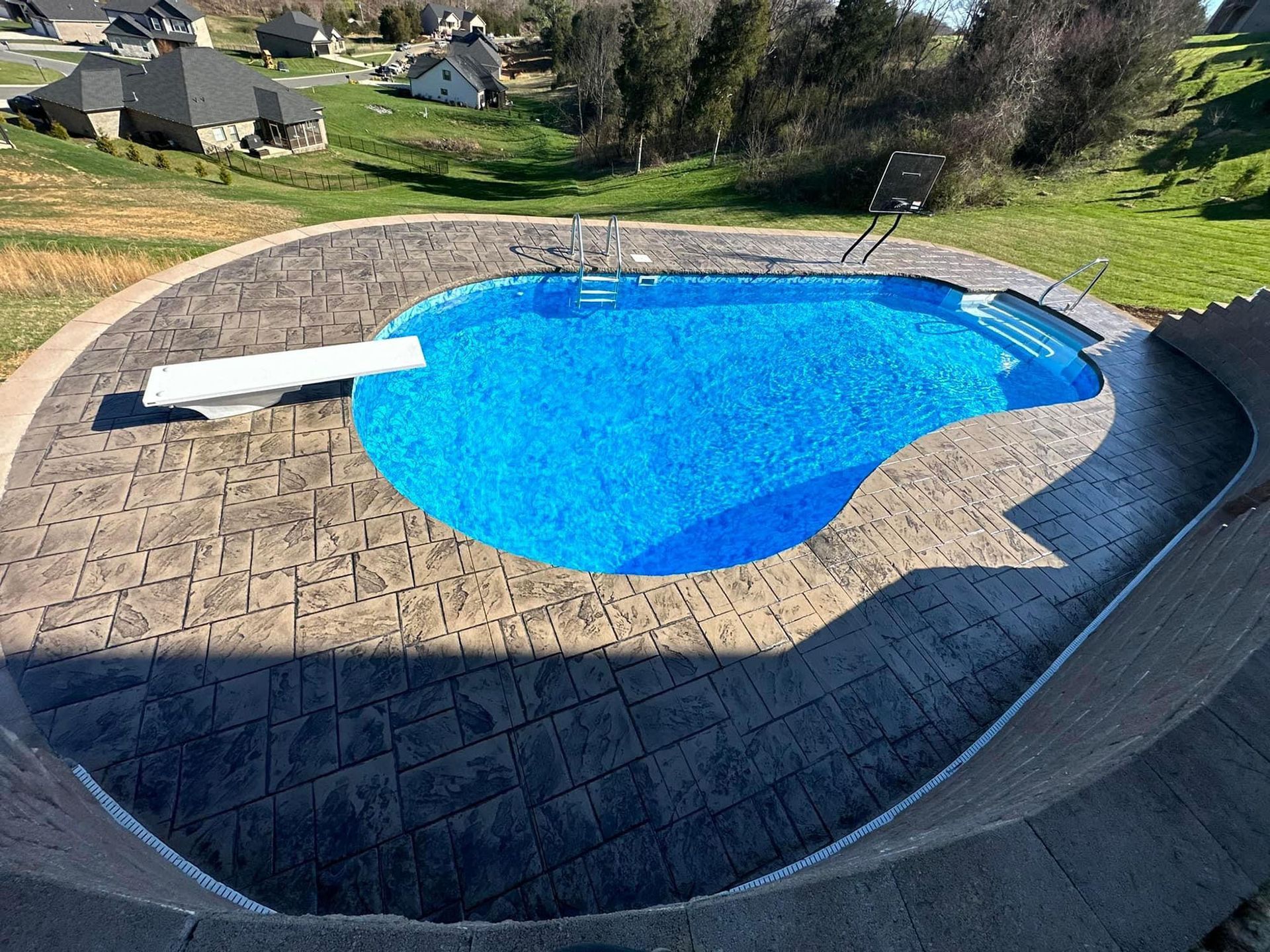 A large swimming pool with a slide in the backyard