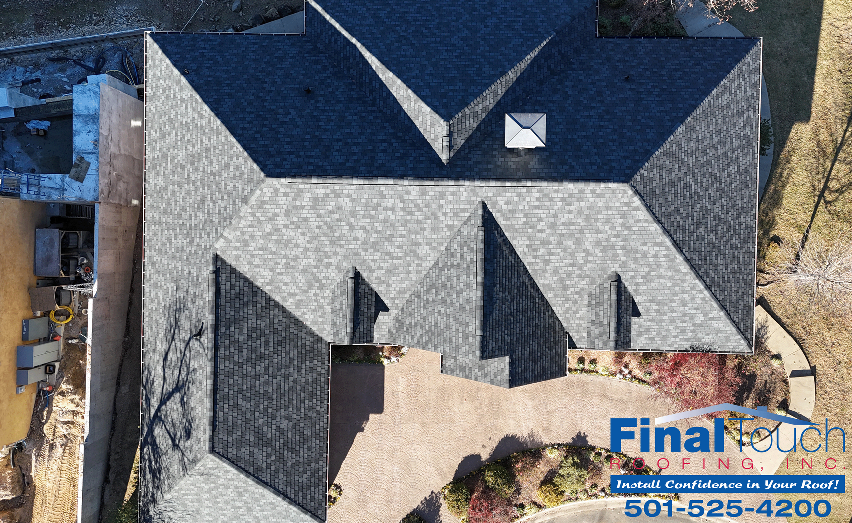 Overhead view of a house with a dark gray shingle roof and brick courtyard.