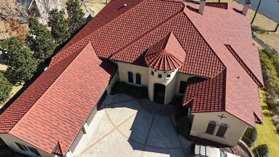 Red tile roofed mansion with beige walls and a circular tower.