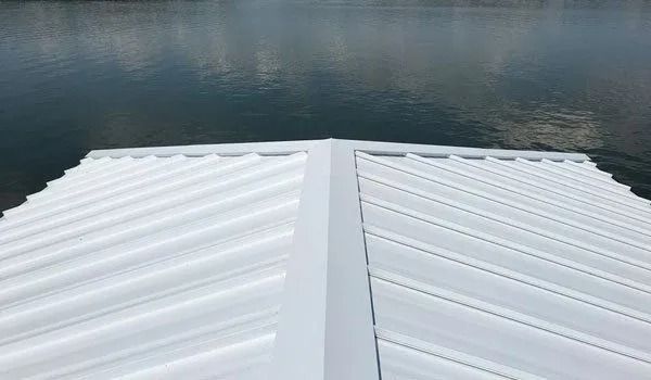 White metal roof angled toward calm water.