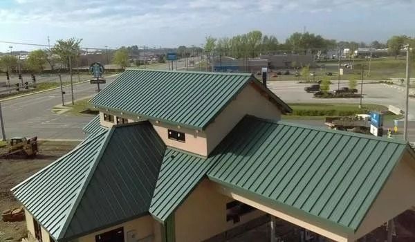 Green metal roof of a commercial building; exterior shot in daytime.