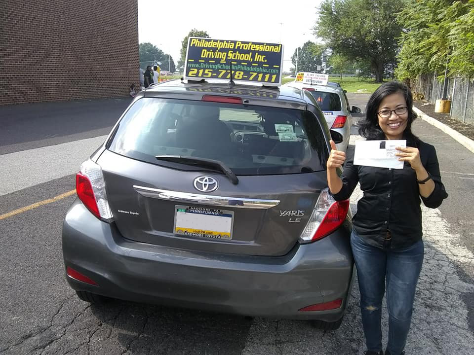 Woman in black shirt doing ok sign after passing driving school test