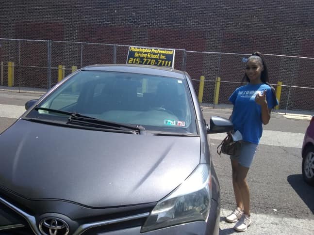 Happy woman in blue shirt passing driving school test