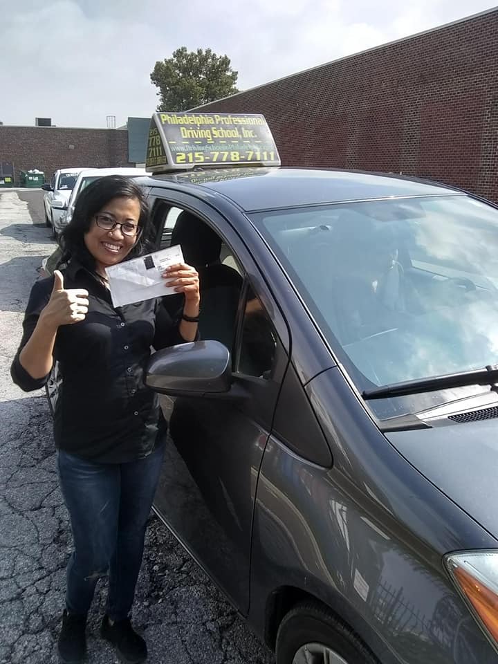 Happy woman in black shirt doing ok sign after passing driving school test