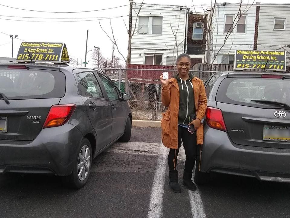 Woman wearing a brown coat holding driver's license