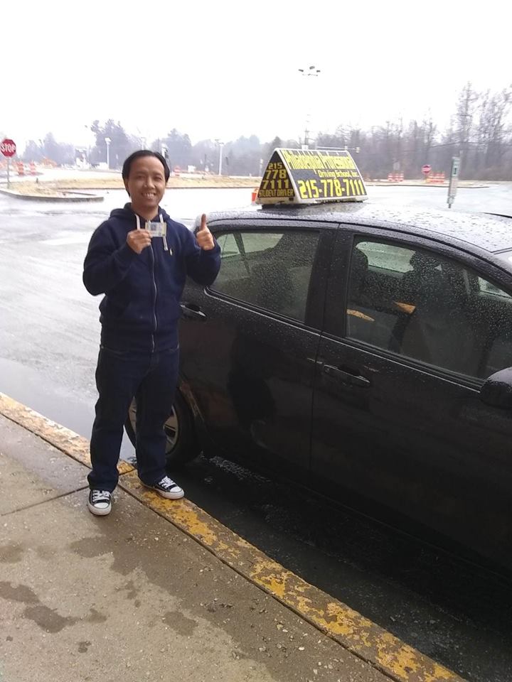 Man holding driver's license and doing ok sign