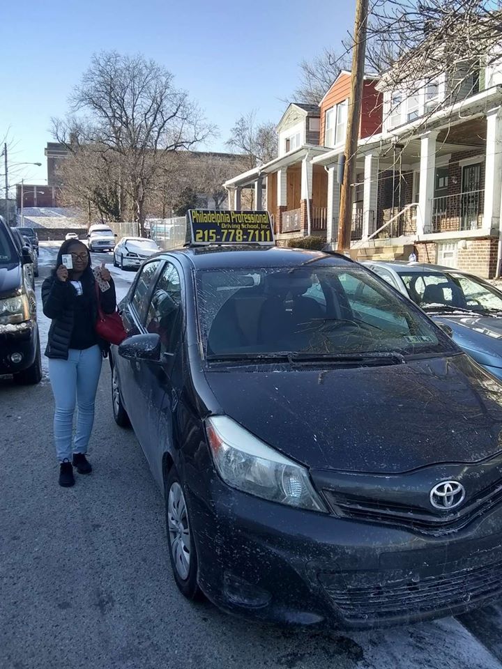 Female holding driver's license and doing ok sign