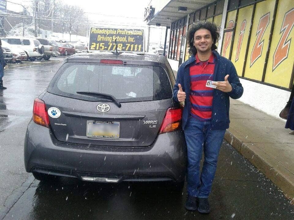 Man holding driver's license and doing ok sign on a snowy day