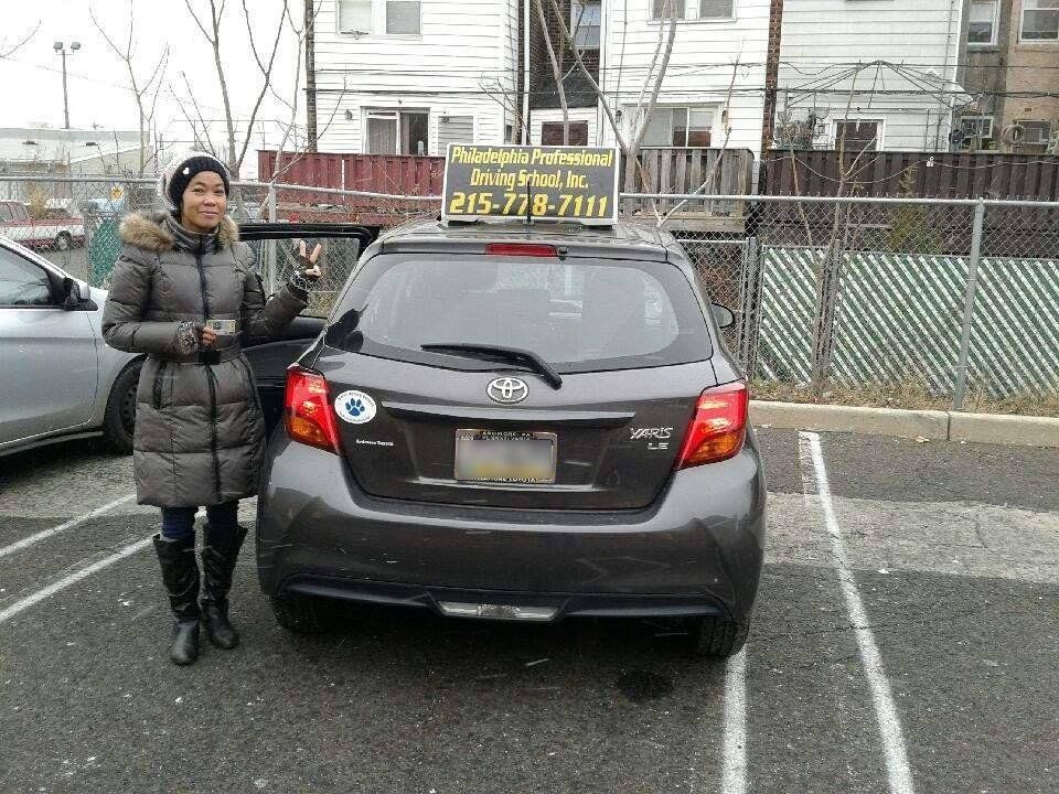 Woman holding driver's license and doing peace sign
