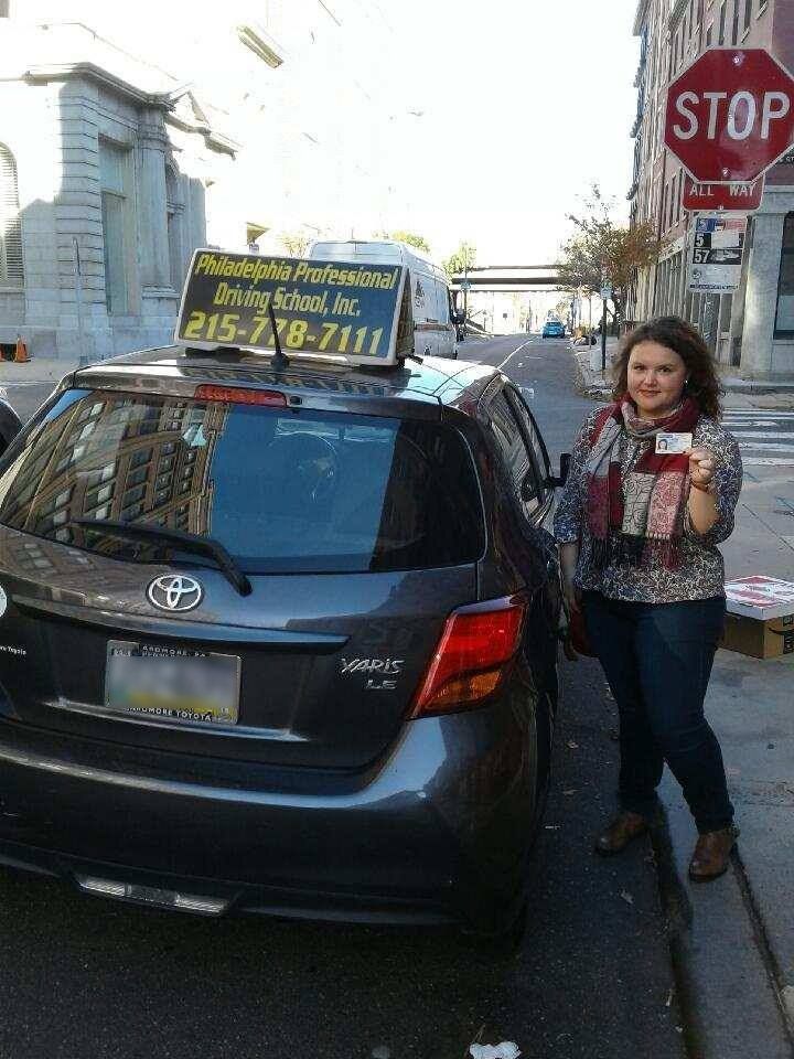 Female wearing a scarf holding driver's license