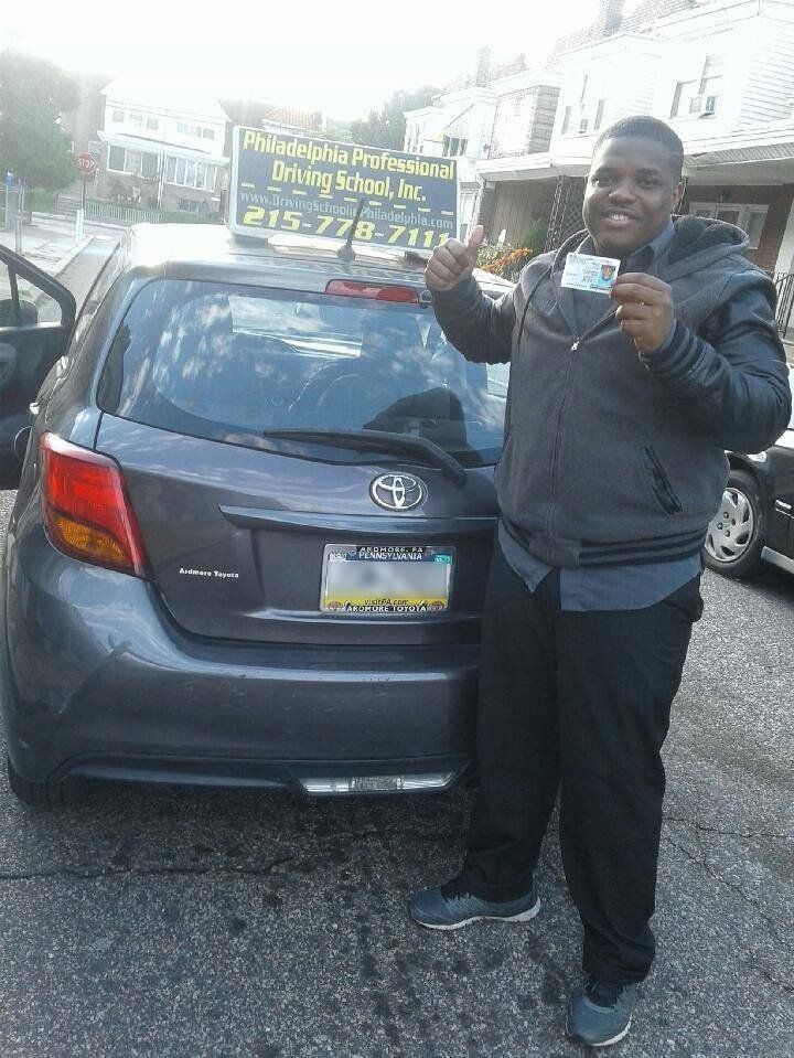 Happy male holding driver's license and doing ok sign