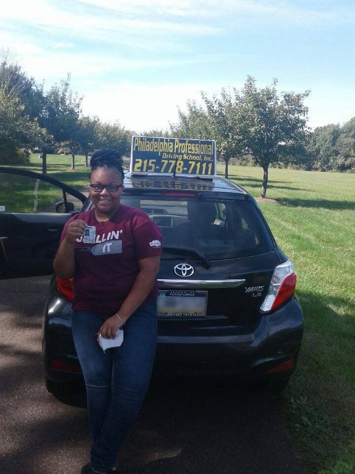 Female holding driver's license after passing driving school test