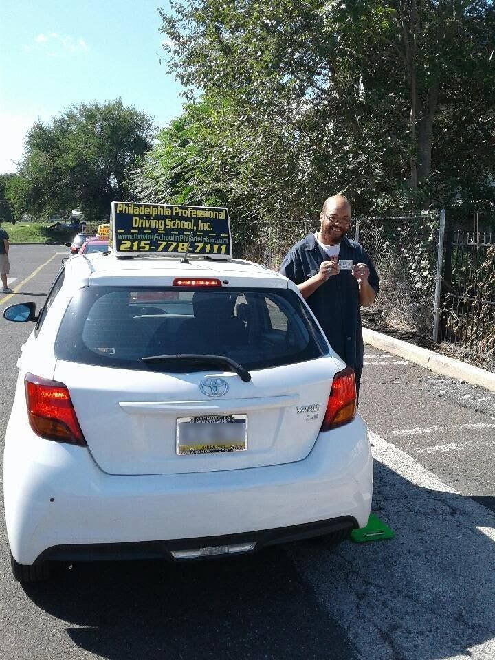 Happy man holding driver's license after passing driving school test