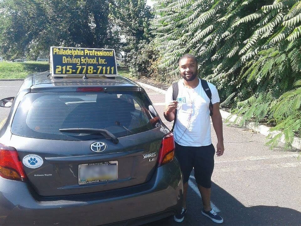 Male in white shirt holding driver's license