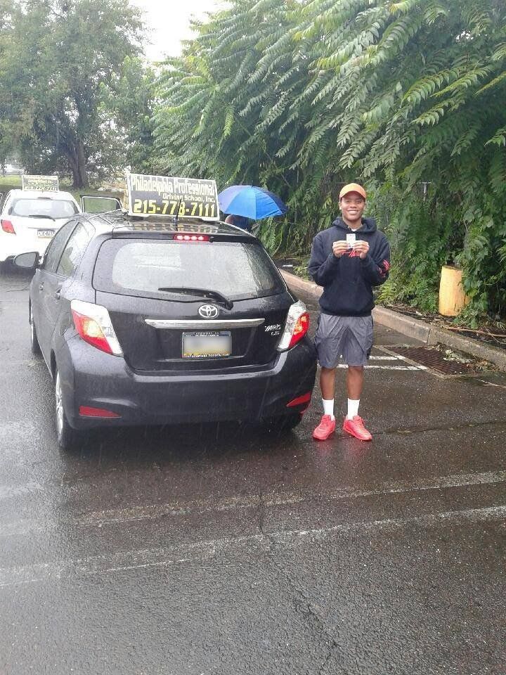 Teen wearing orange cap holding driver's license