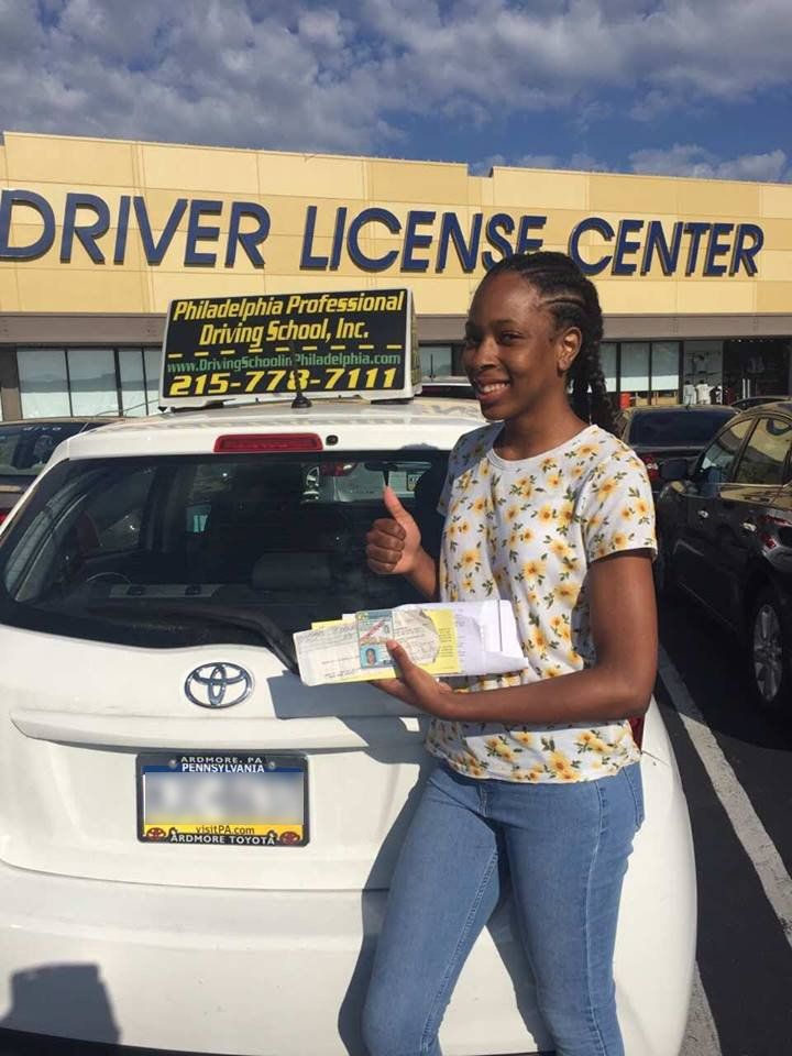 Smiling woman doing ok sign and holding driver's license
