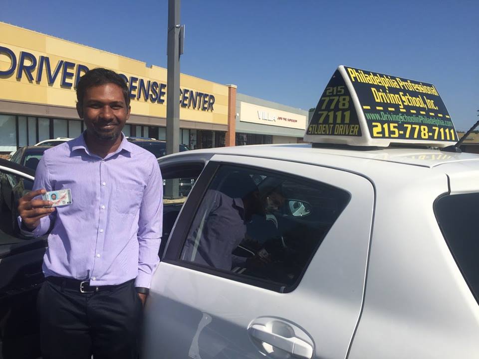 Male holding driver's license after successfully passing driving school test