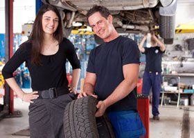 Mechanic showing tire to a female customer