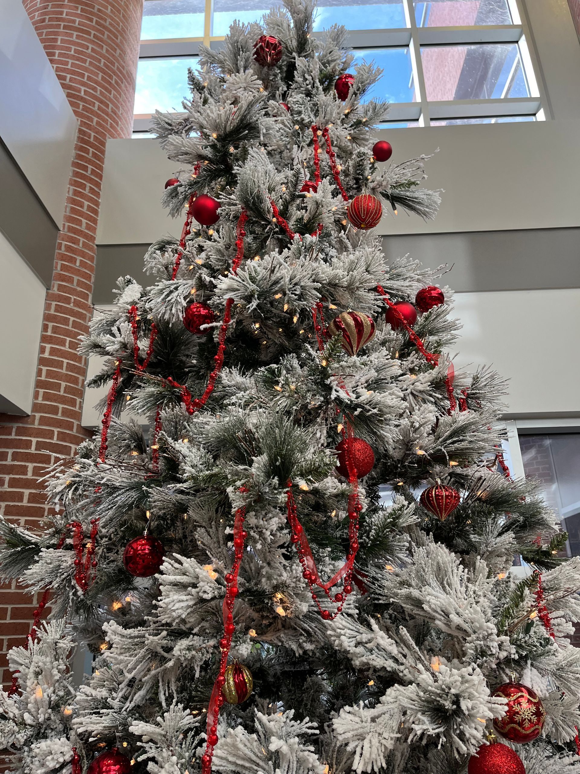 A christmas tree with red decorations and snow on it