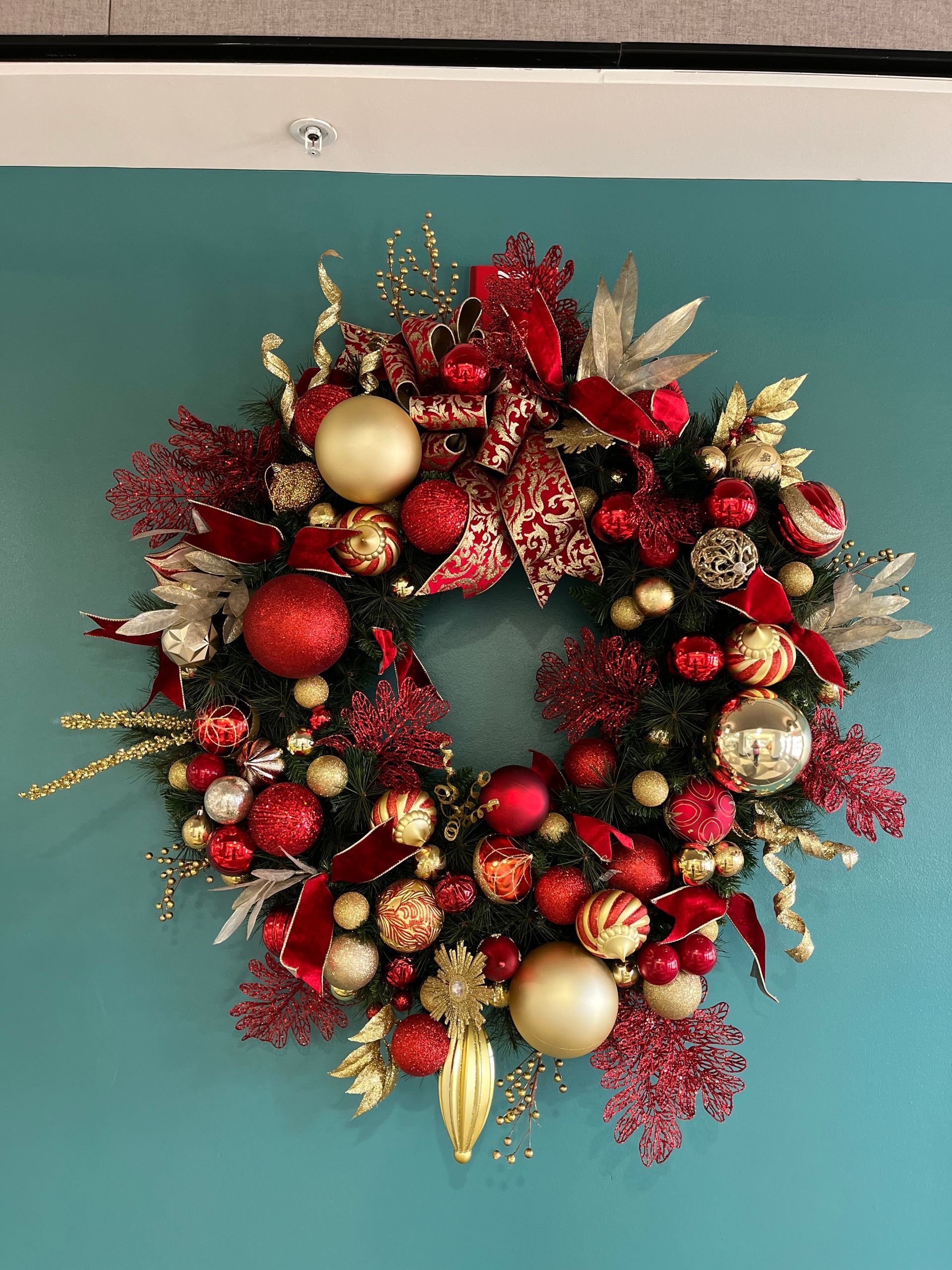 A christmas wreath is hanging on a blue wall