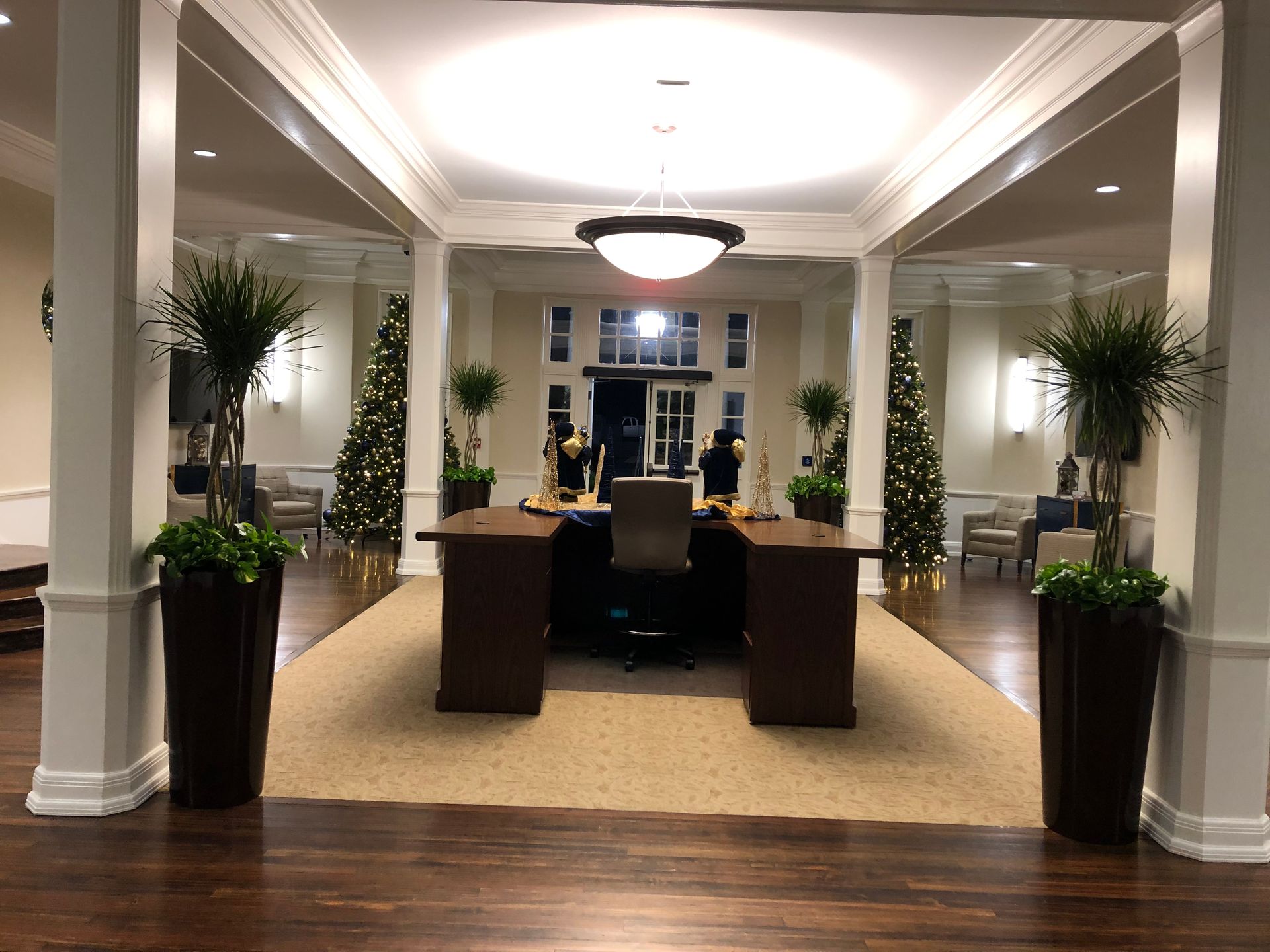 A large room with two desks and christmas trees
