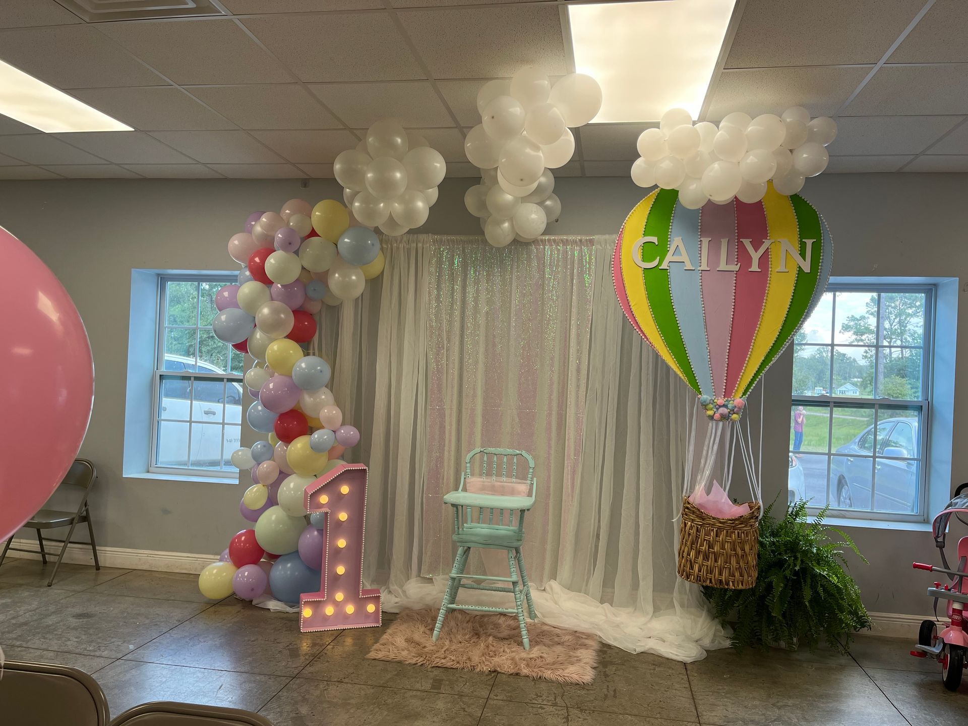 A room decorated with balloons and a hot air balloon for a birthday party.