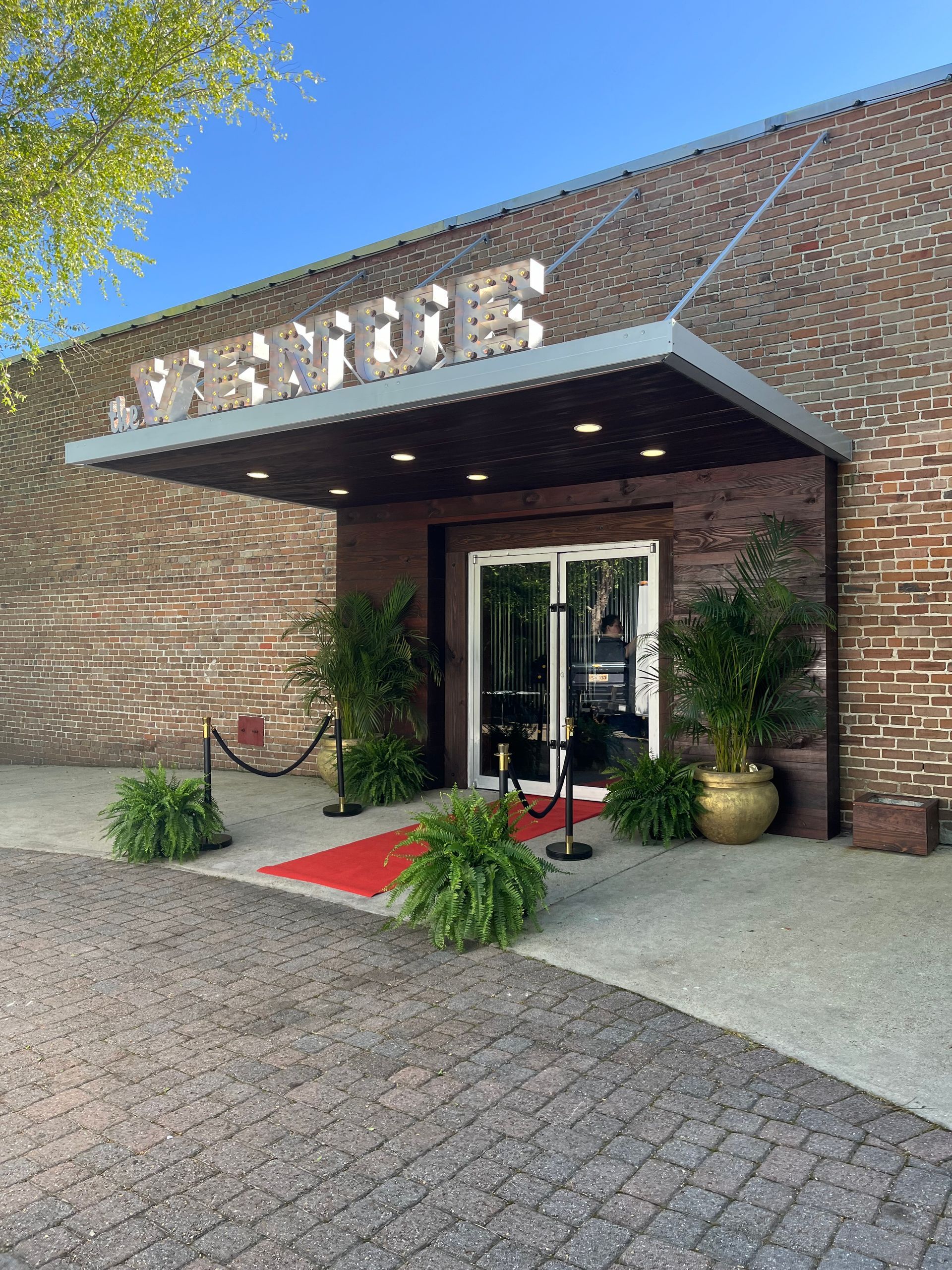A brick building with a canopy over the entrance and a red carpet.