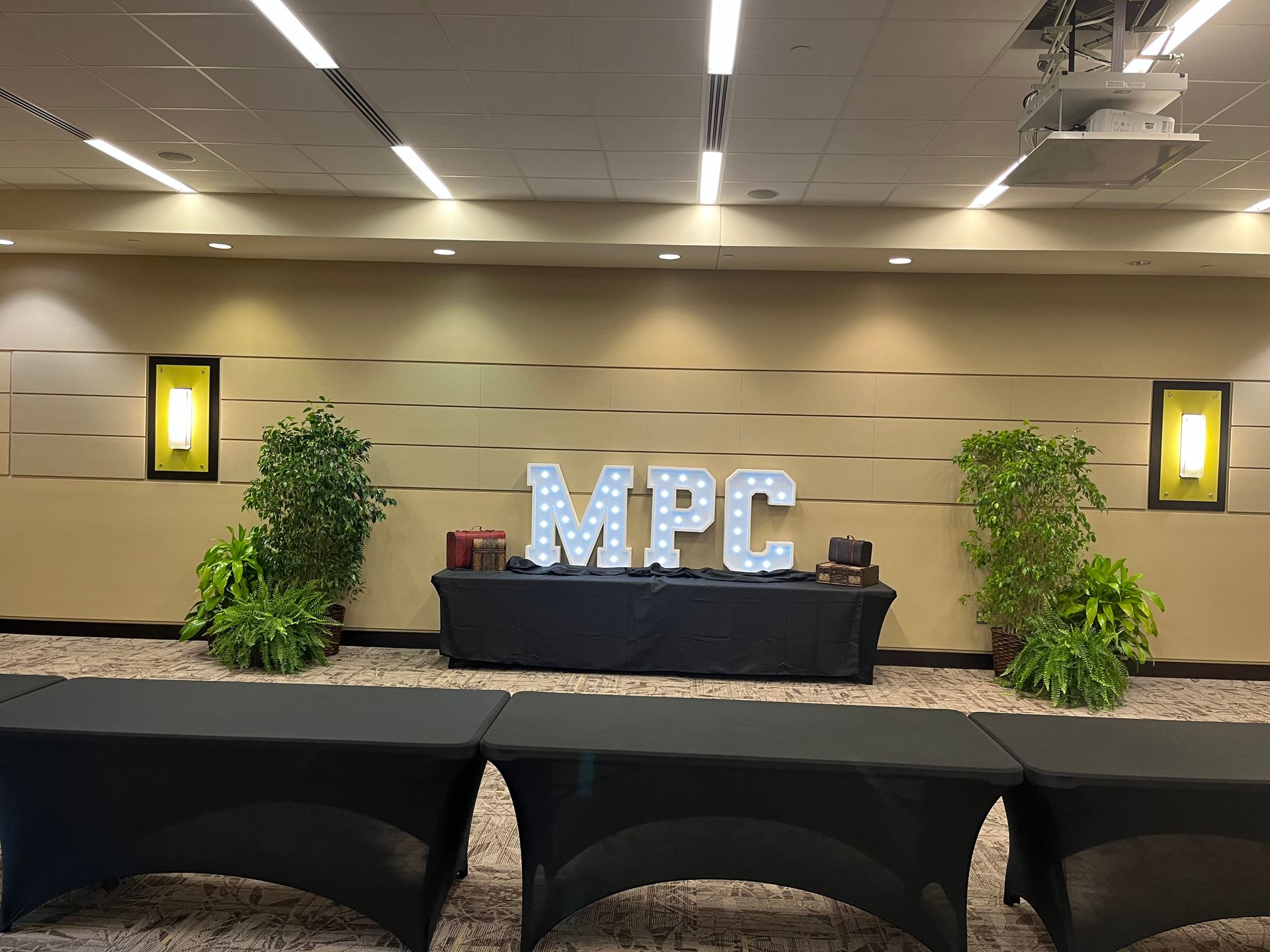 A room with tables and a sign that says mpc on the wall.