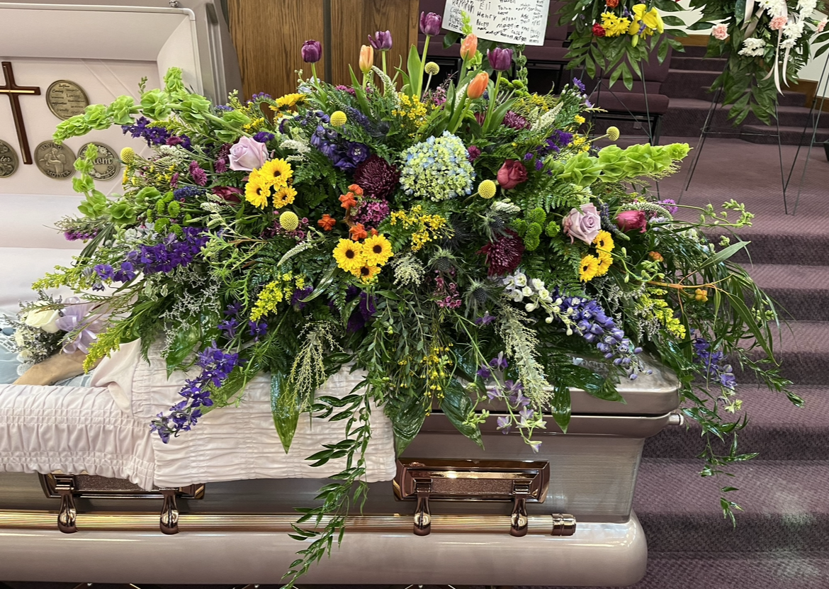 A coffin with flowers on it in a church.