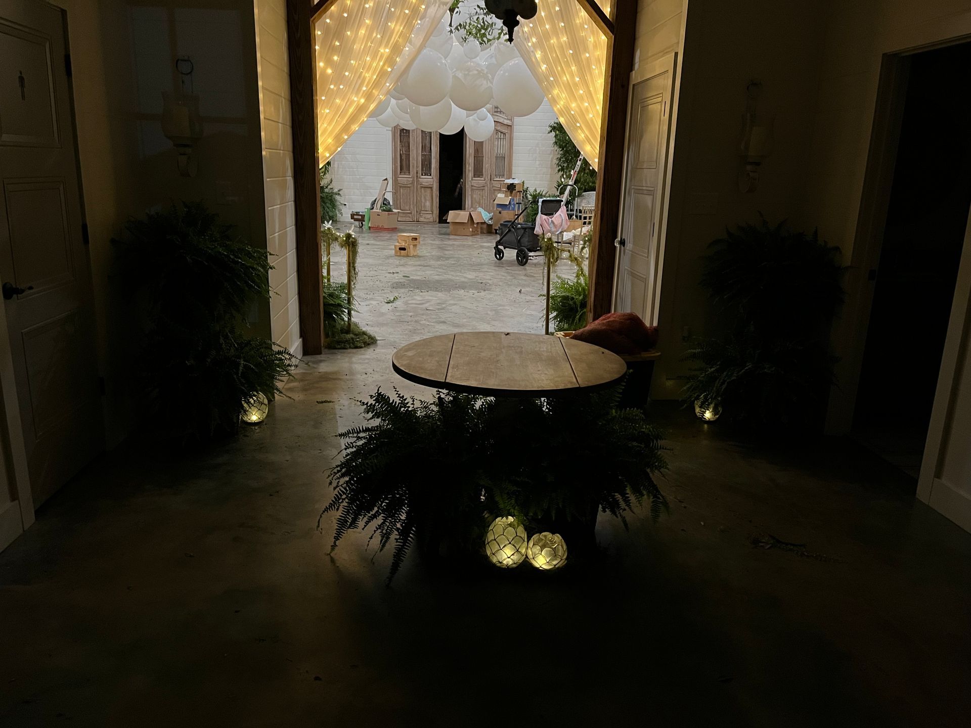 A dark room with a table and plants in it.