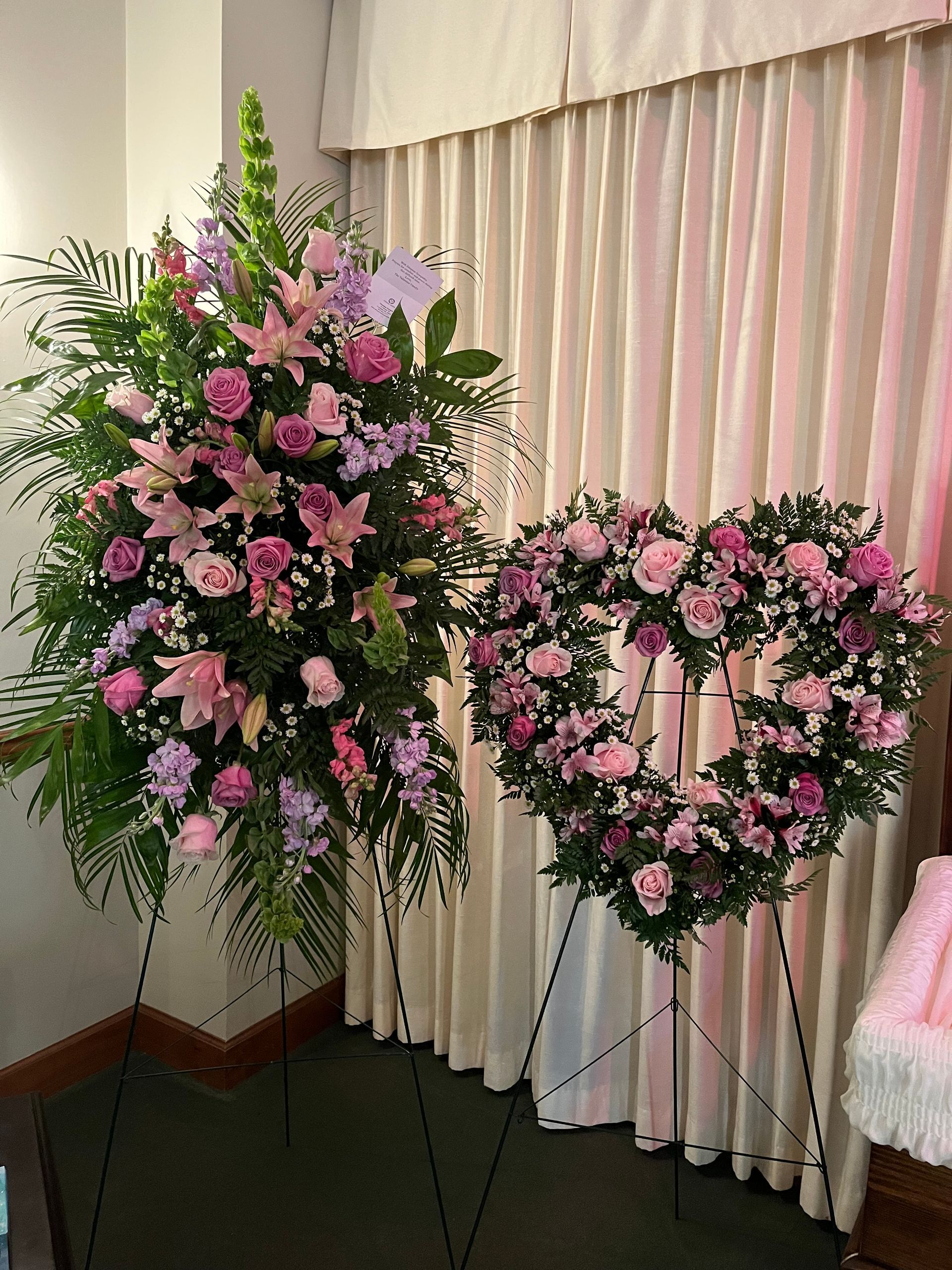 Two heart shaped wreaths are sitting next to each other in a room.