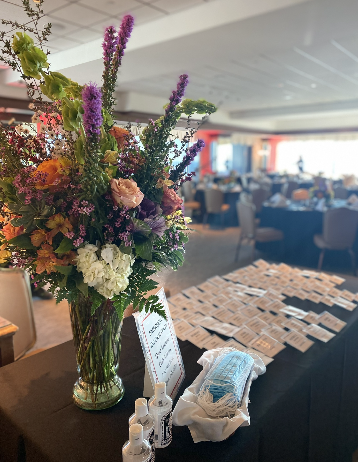 A table with a vase of flowers and cards on it