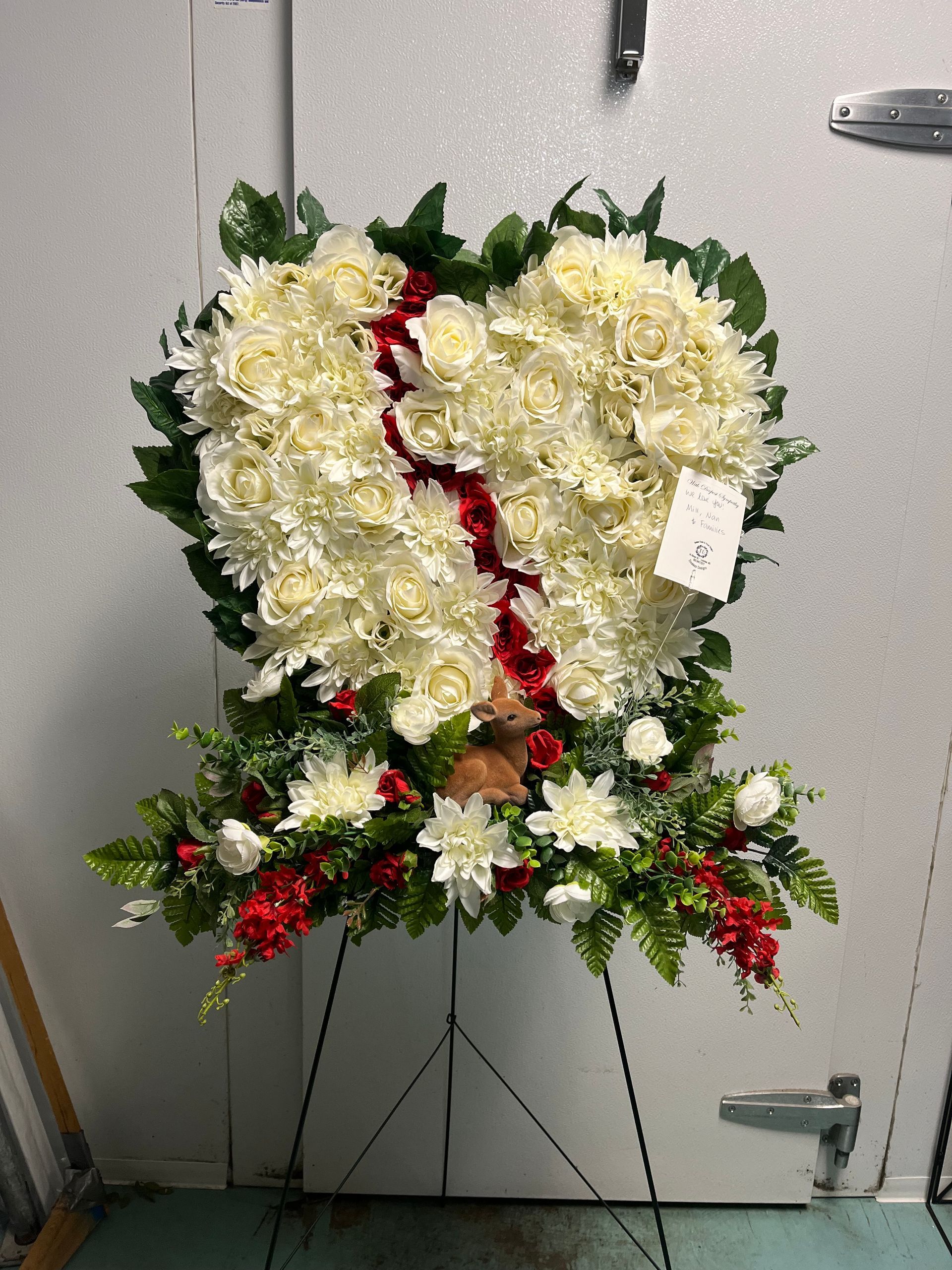 A heart shaped wreath made of white flowers and red flowers