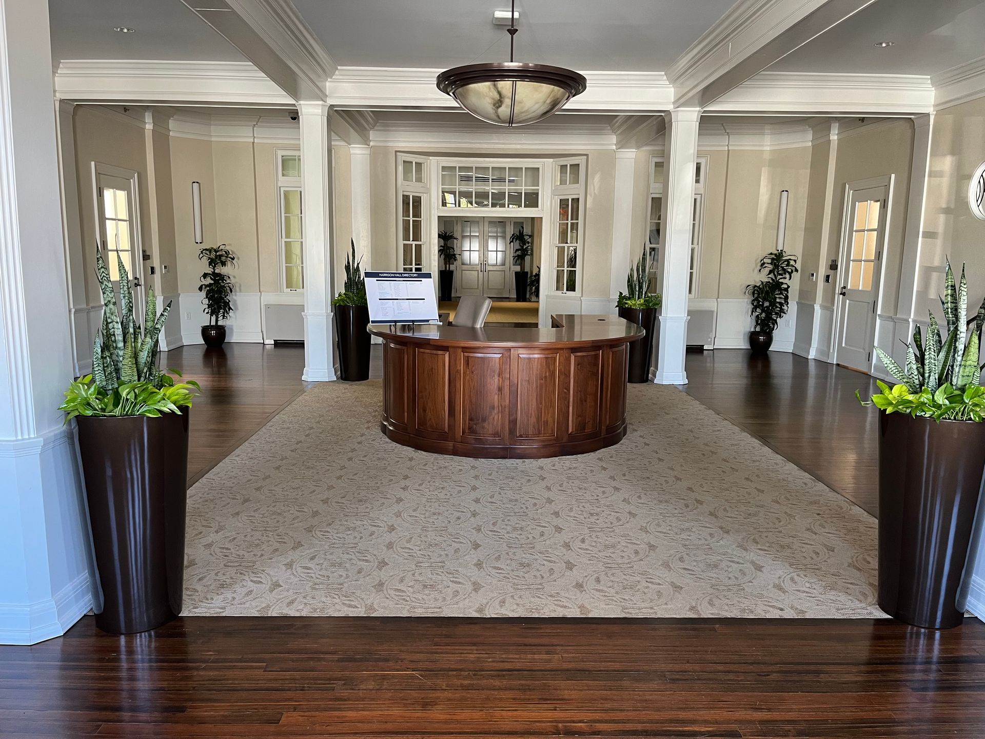 A large room with a wooden table and potted plants