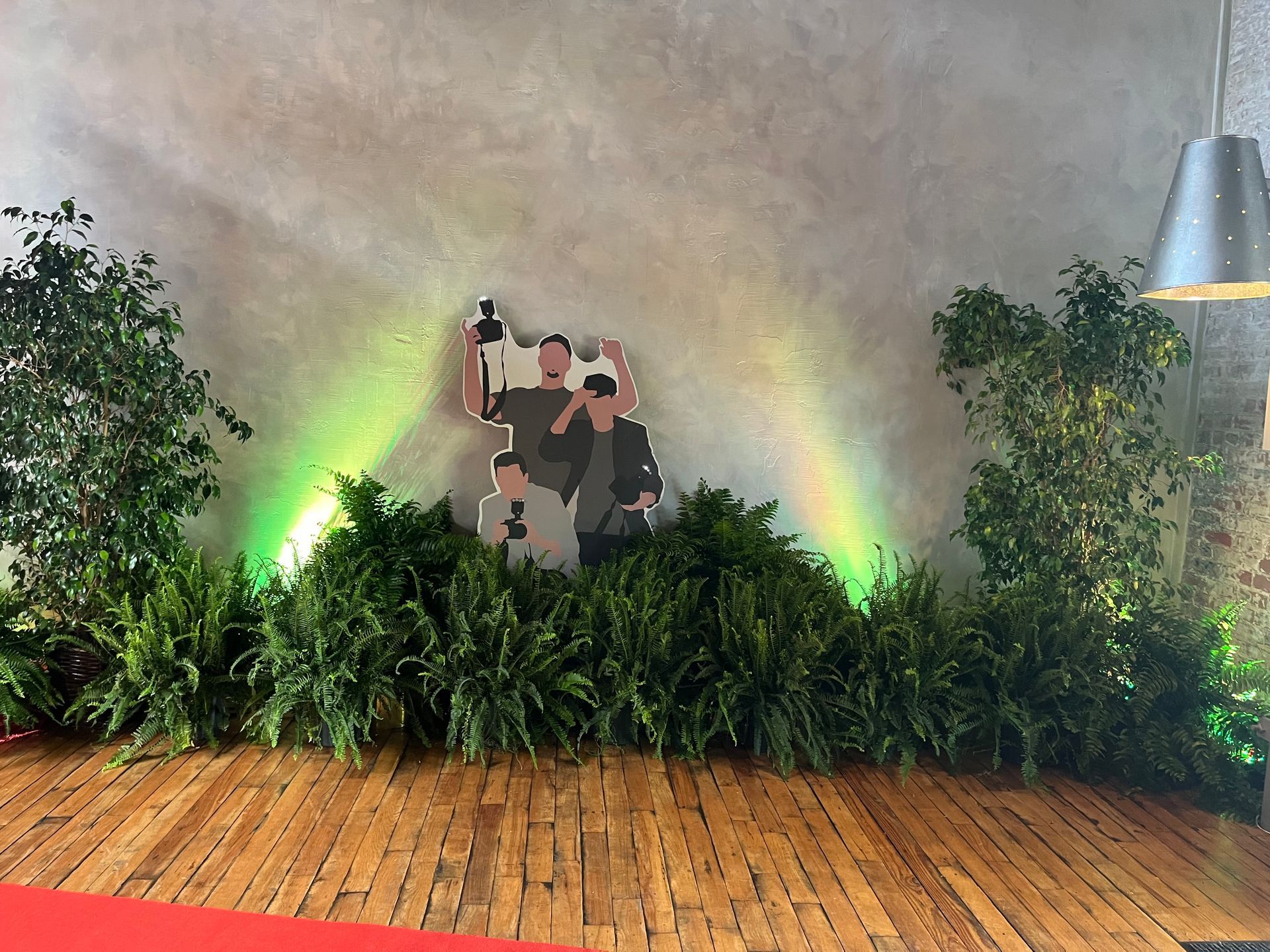A picture of two people standing next to each other on a wall surrounded by plants.