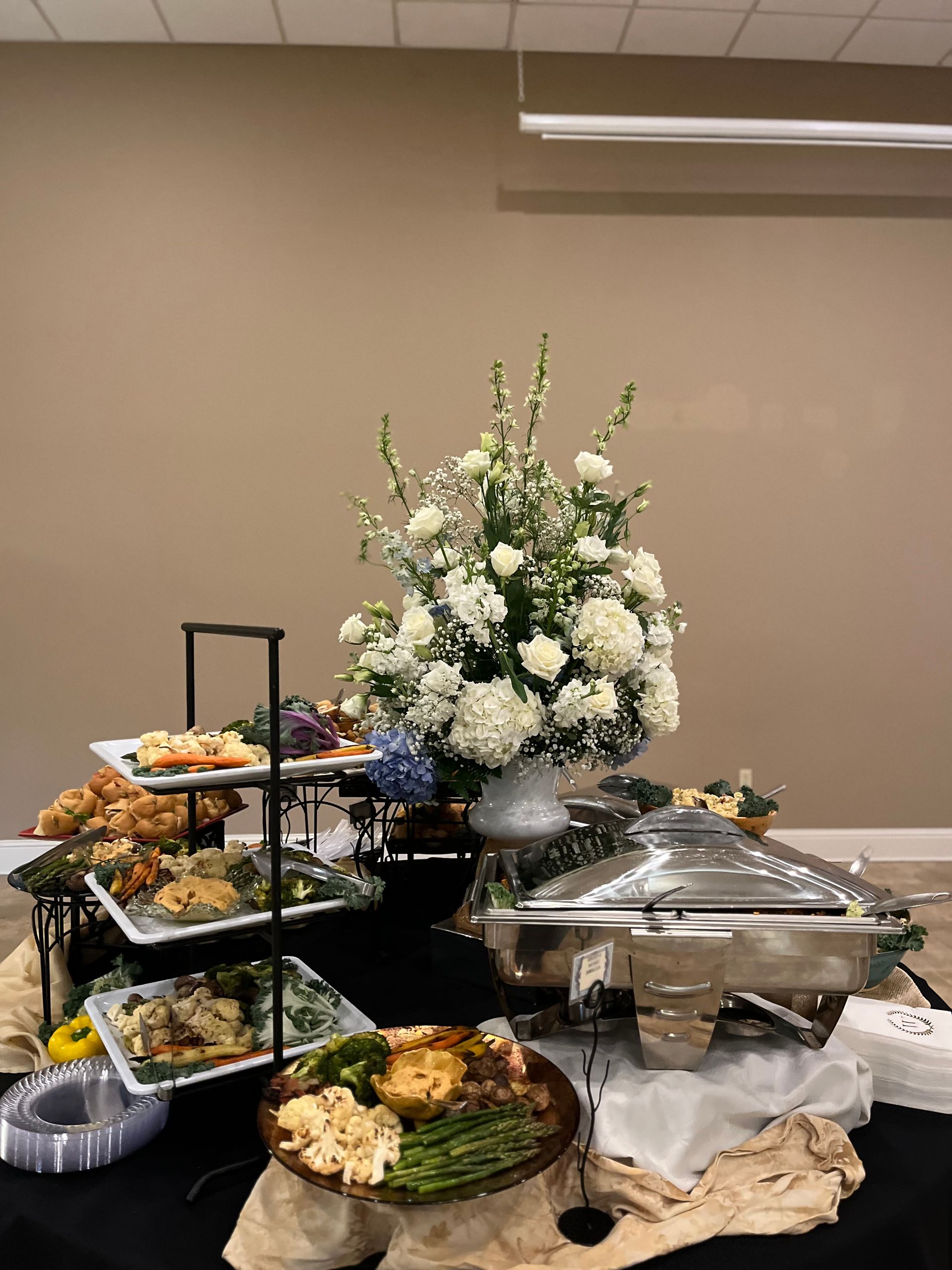 A buffet table with a vase of flowers on top of it.