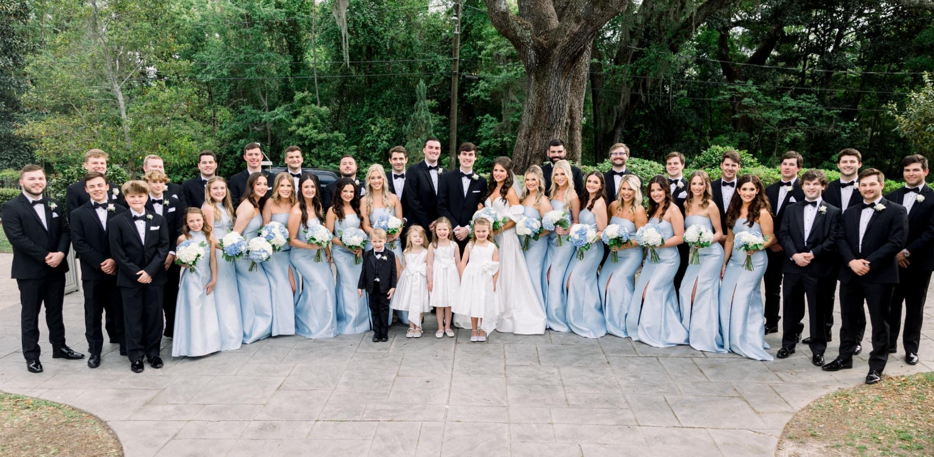 A large group of people are posing for a picture at a wedding.