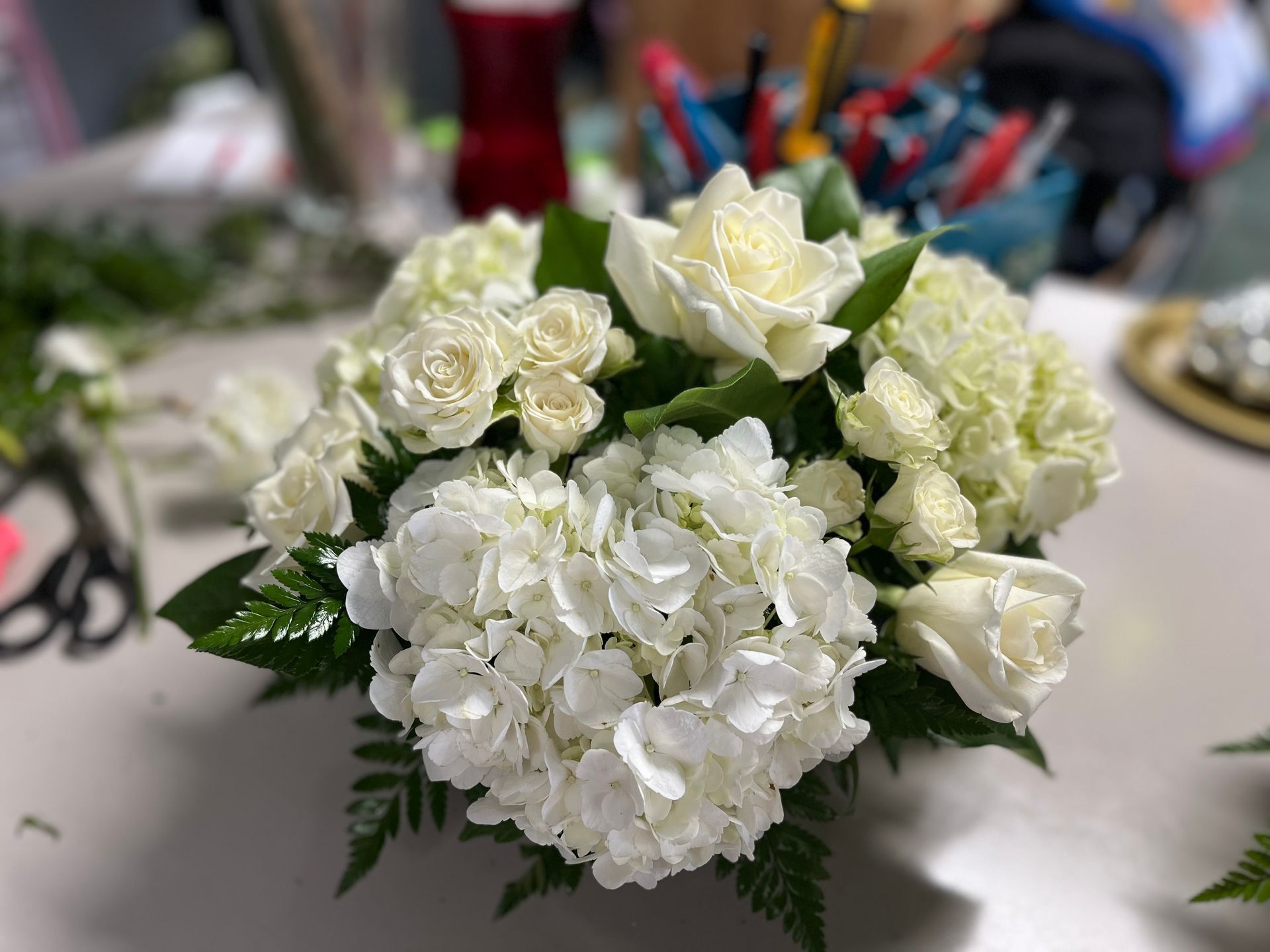 A vase filled with white flowers is sitting on a table.